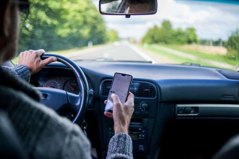 A man texting while driving a car